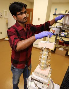 Manoj Kodigudla, research engineer in Dr. Vijay Goel’s lab, made adjustments to the spine testing device in the lab.